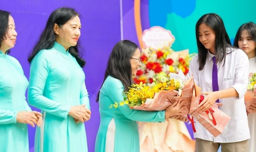 Cô giáo vui vẻ nhận hoa từ học sinh