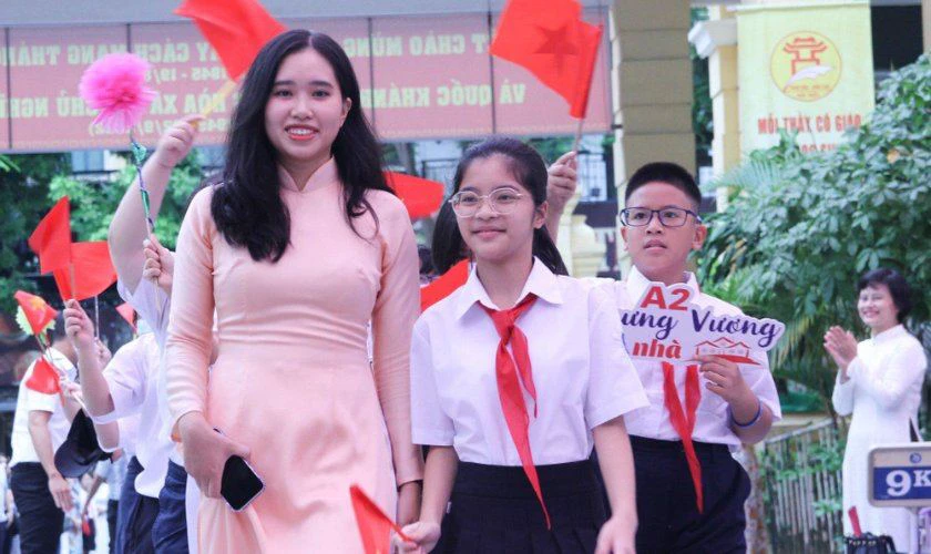 Cô giáo dẫn các em đi khai giảng