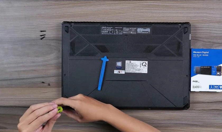 Sử dụng tua vít để tháo các ốc vít ở mặt đáy laptop
