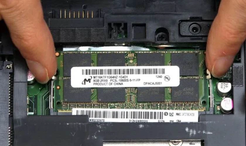 Nhấn nhẹ vào hai chốt giữ ở hai bên để tháo thanh RAM cũ ra