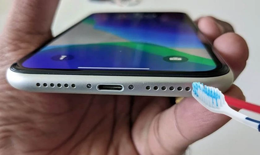 Vệ sinh loa iPhone 12 Pro Max bằng bàn chải mềm khi âm bị nhỏ