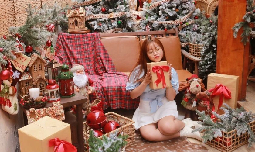 Tạo dáng ngồi chụp ảnh Noel với các hộp quà