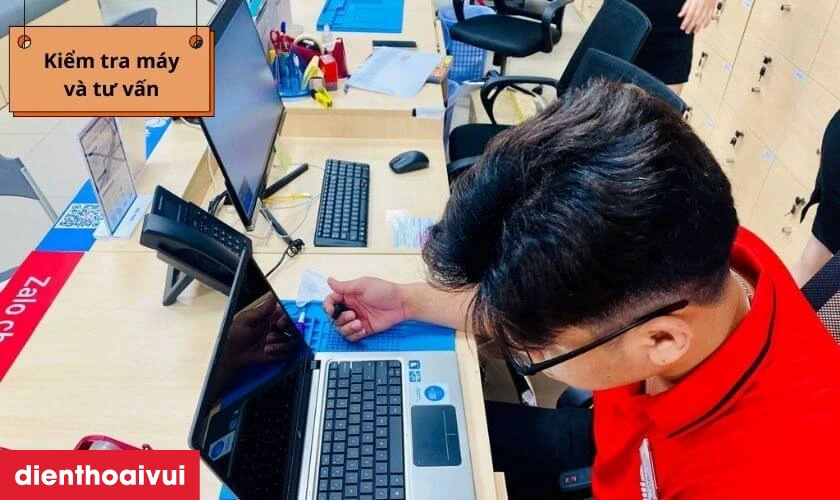 Kỹ thuật viên nhận máy kiểm tra và báo giá cho khách hàng