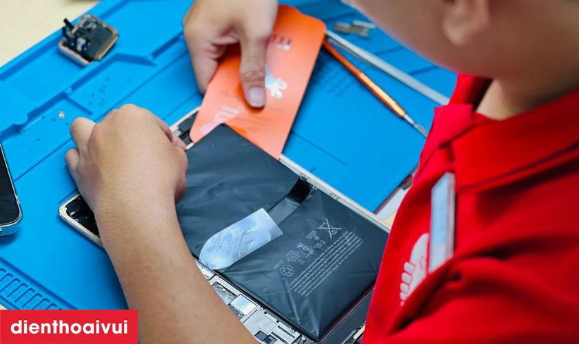 Kỹ thuật viên tháo máy bằng dụng cụ chuyên dụng và thay pin mới