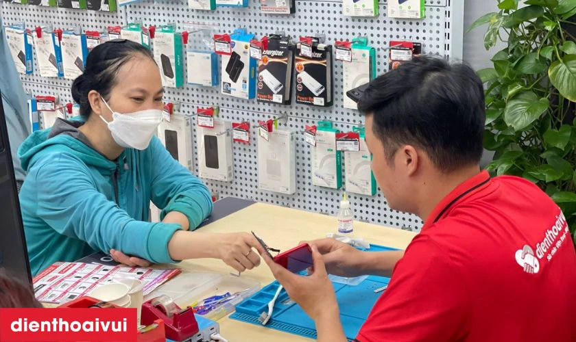 Nhân viên cửa hàng tiếp nhận điện thoại Samsung J7 từ khách hàng