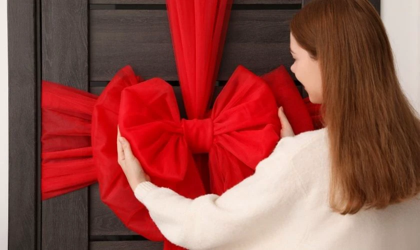 Trang trí cửa sổ Giáng Sinh với nơ đỏ xinh xắn