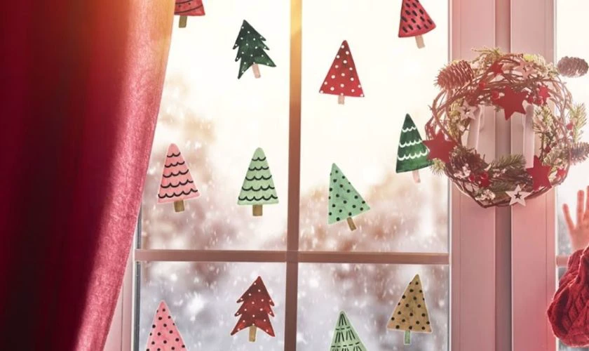 Vẽ cây thông nhiều màu lên cửa sổ để trang trí