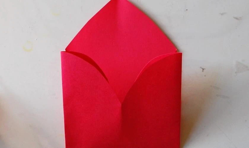 Gấp phần đỉnh trái tim xuống, tạo hình phong thư, nên căn chỉnh cho các nếp gấp cân đối