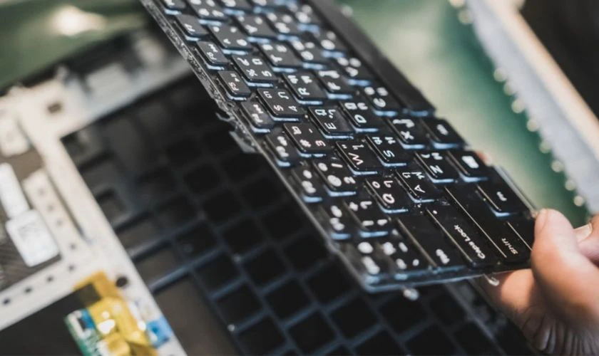Nhấc bàn phím lên nhẹ nhàng và rút cáp kết nối với mainboard