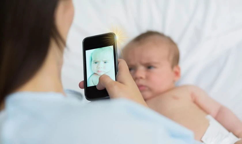 T&aacute;c hại của đ&egrave;n flash điện thoại chiếu v&agrave;o mắt trẻ sơ sinh