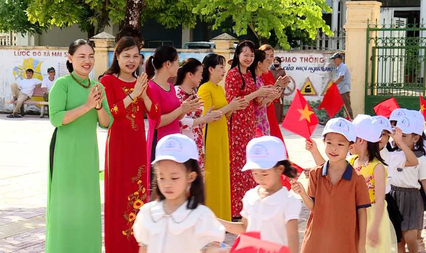 Hình ảnh cô giáo đang chào đón các em học sinh