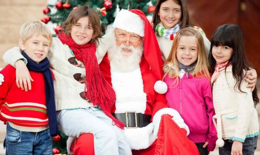 Santa Claus chụp h&igrave;nh c&ugrave;ng trẻ em