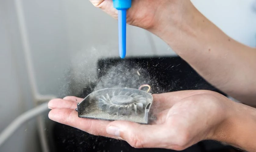 Dùng một ngón tay giữ cố định cánh quạt
