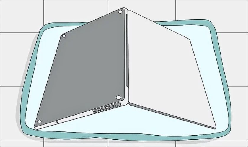 Bạn mở laptop một góc 45 độ và đặt úp ngược trên tấm khăn