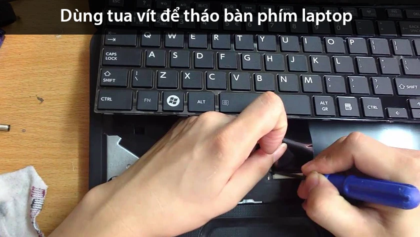 Dùng tua vít tháo ốc bàn phím laptop hp